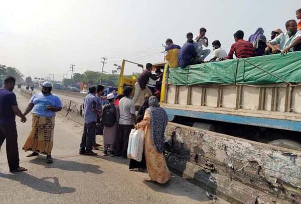 বাস না থাকায় পণ্যবাহী ট্রাকে করে না:গঞ্জ ছাড়ছে মানুষ